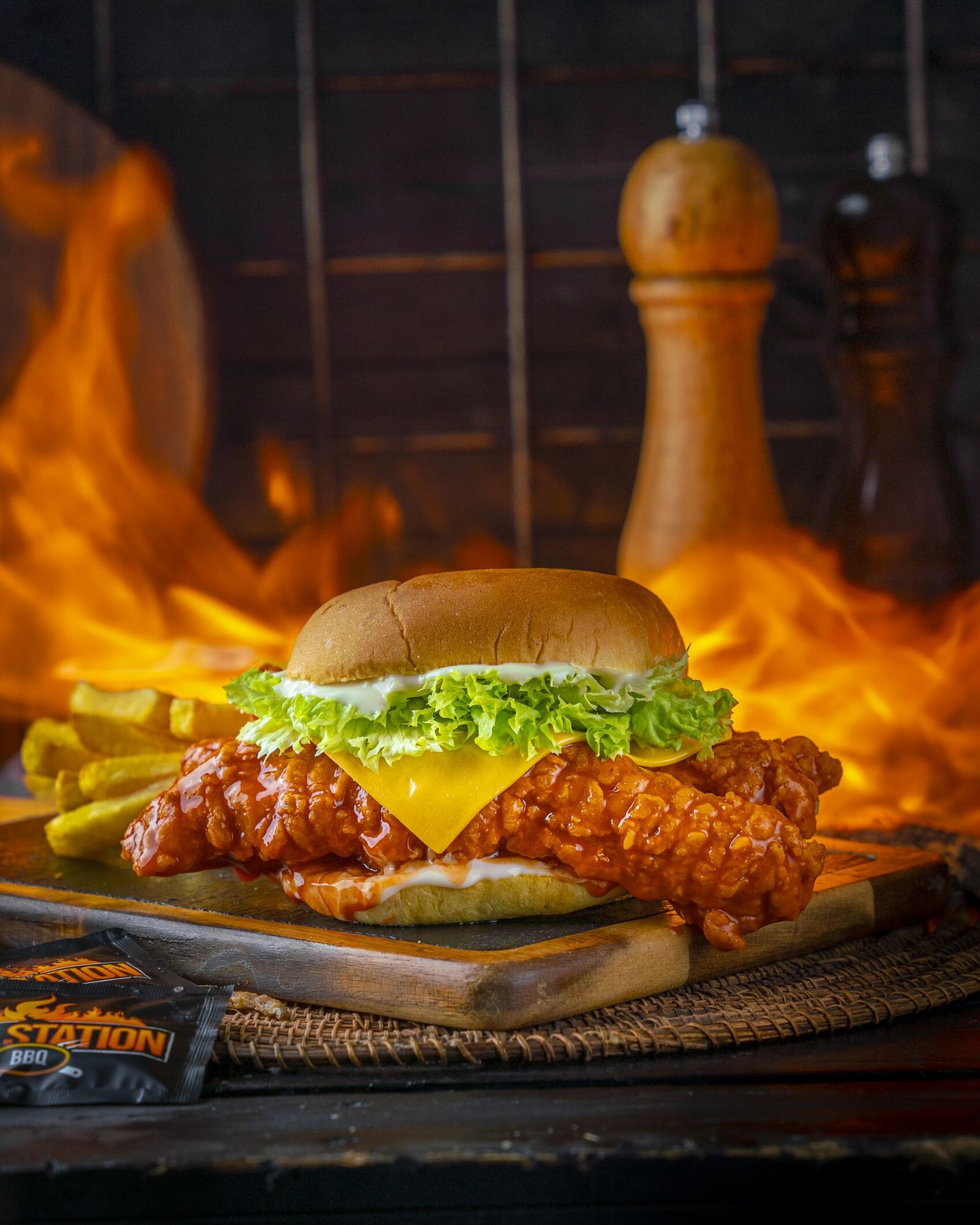 Hot chicken burger with cheese and lettuce over open flames