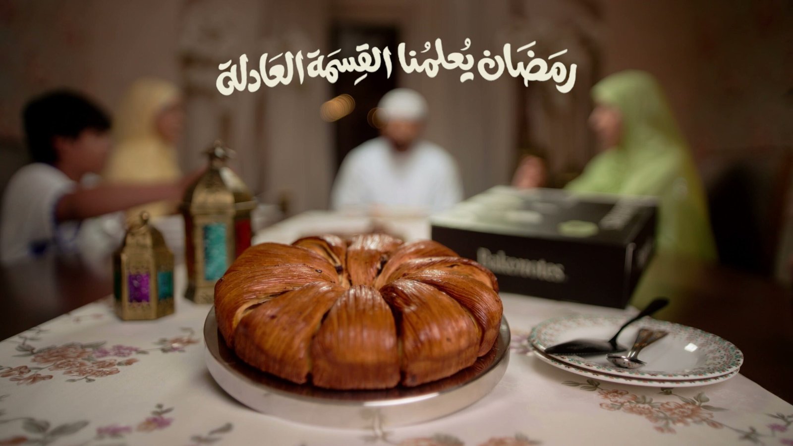 Ramadan table with a pull-apart bread ring and lanterns, a family seated behind it