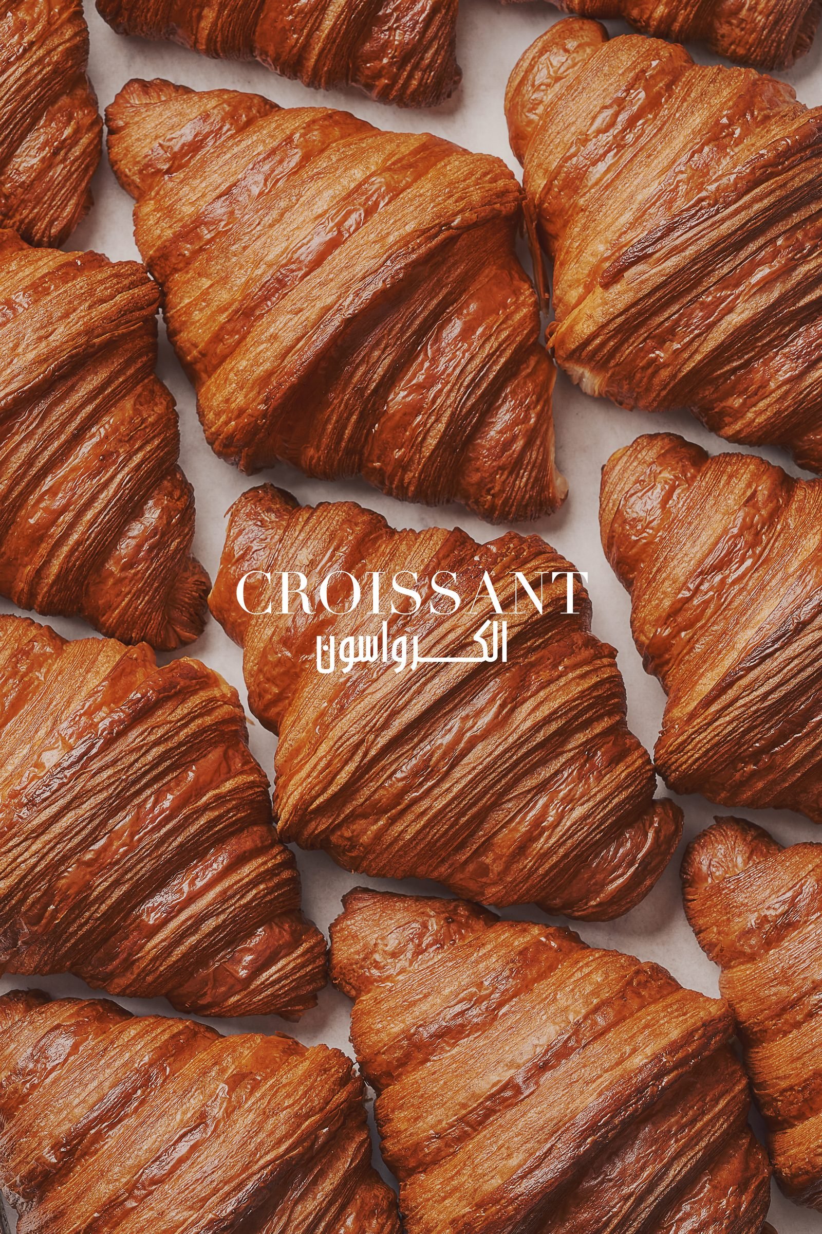 Grid of croissants filling the frame with the word Croissant across them