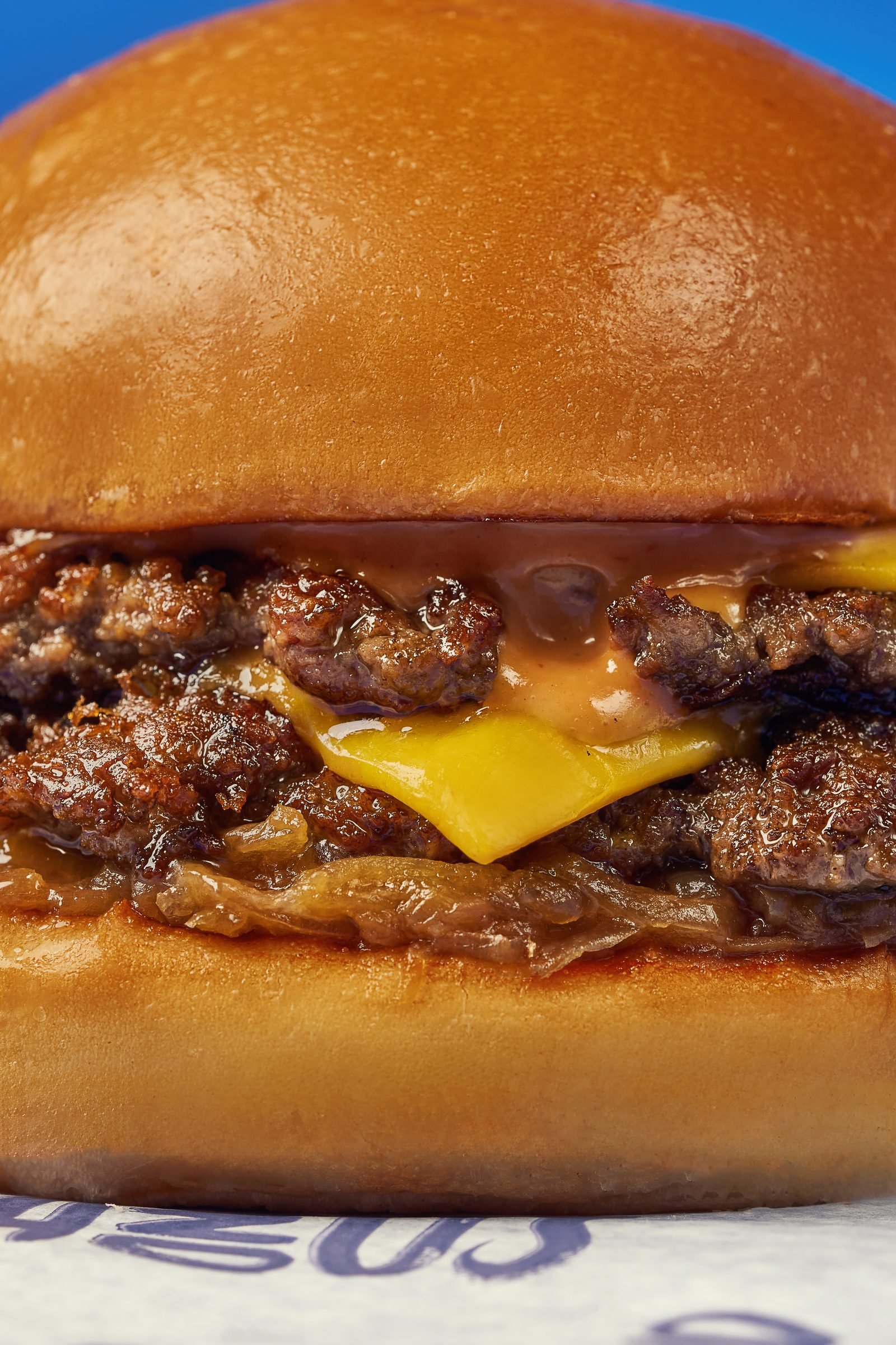 Close-up of a beef and cheese slider on a brioche bun