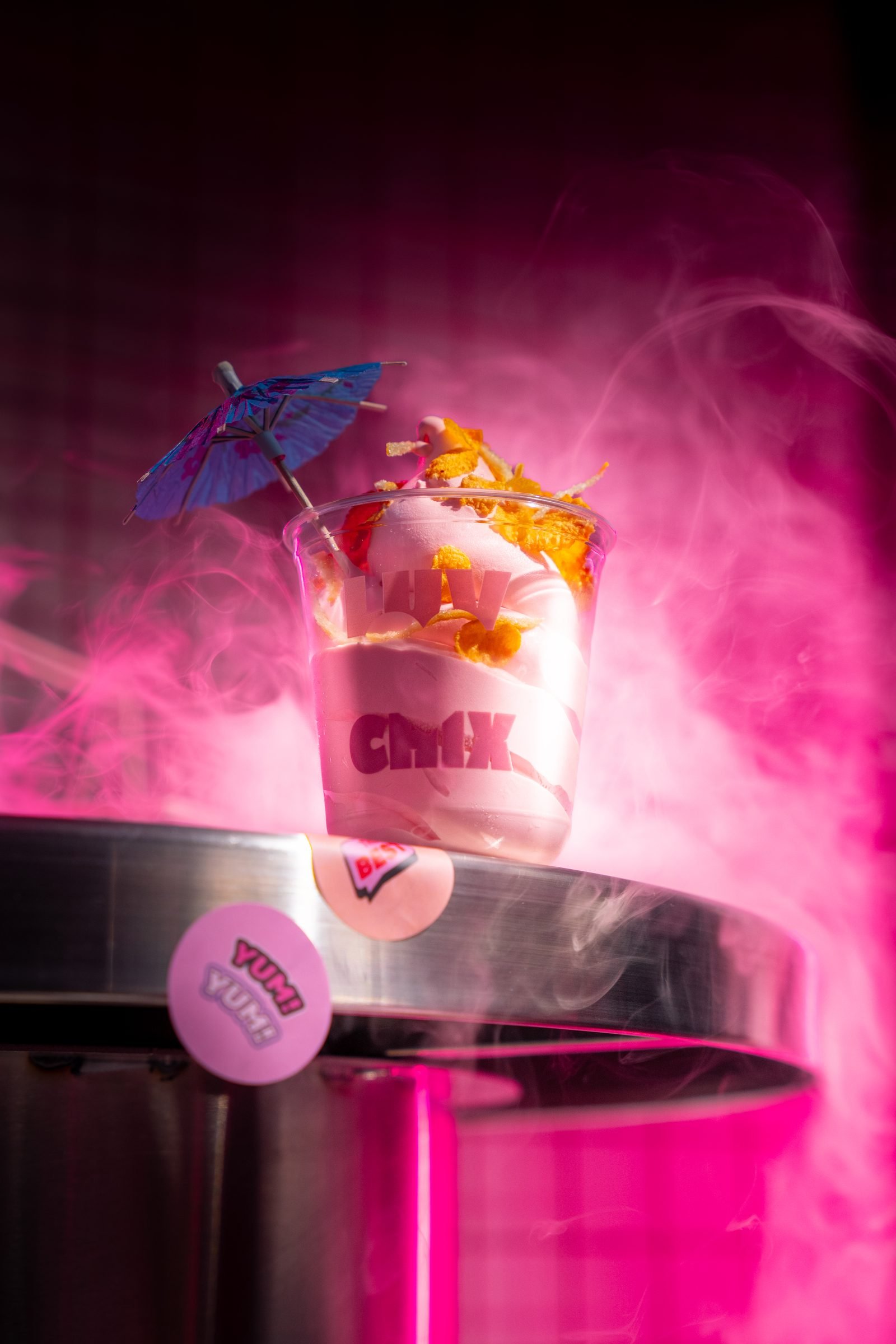 Loaded chicken cup with a cocktail parasol, in magenta smoke
