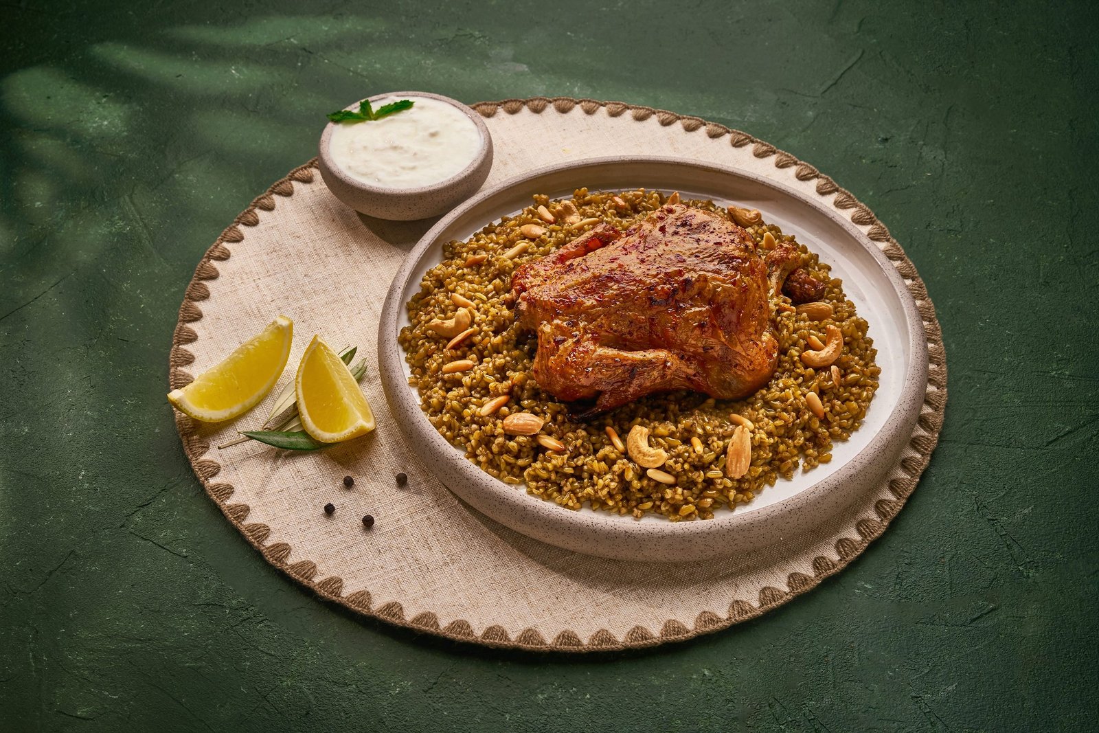 Roast chicken quarter on herbed rice on a scalloped plate with lemon and yoghurt