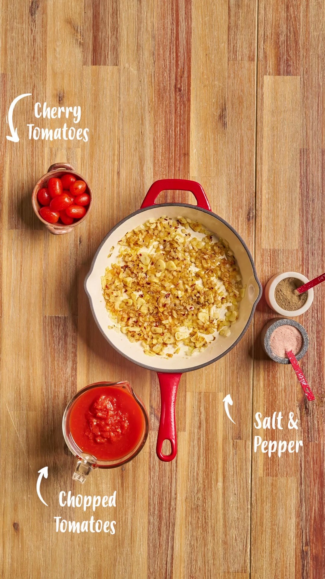 Pan of creamy pasta on wood, labelled with its ingredients: cherry tomatoes, salt and pepper