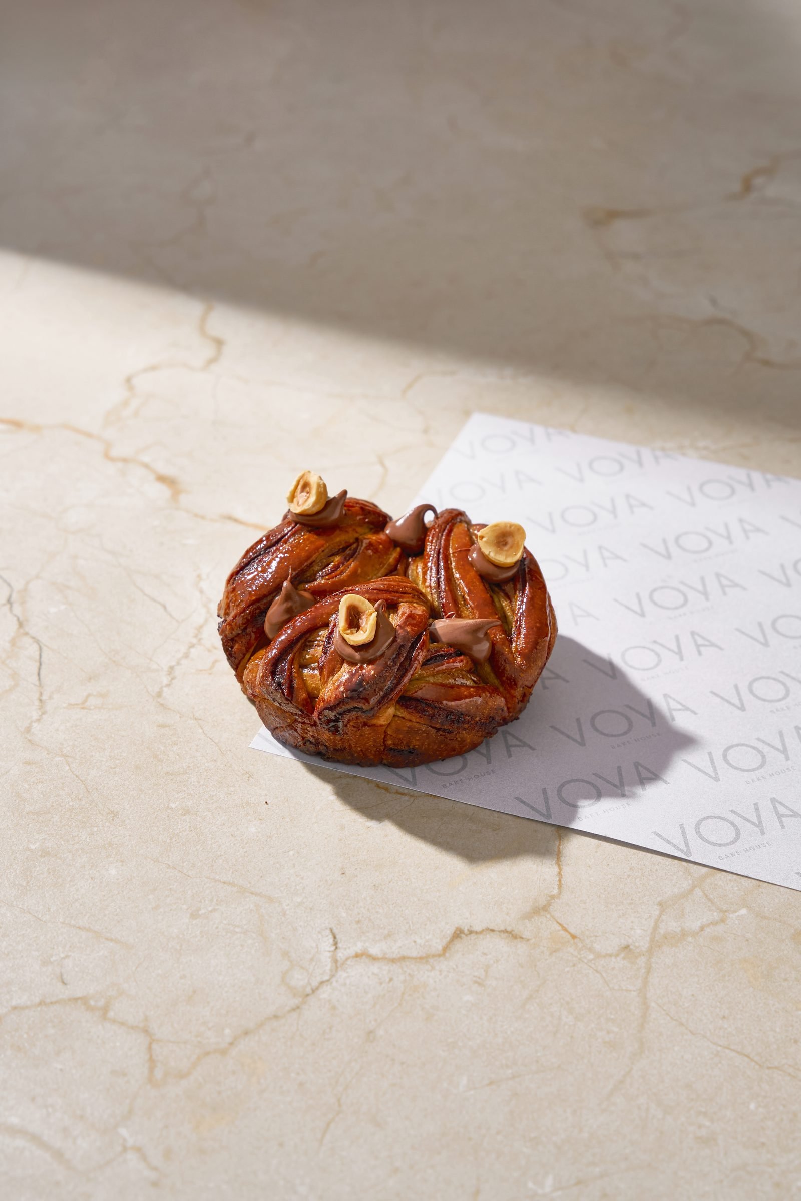 Cinnamon and pecan pastry twist on Voya paper on cream marble