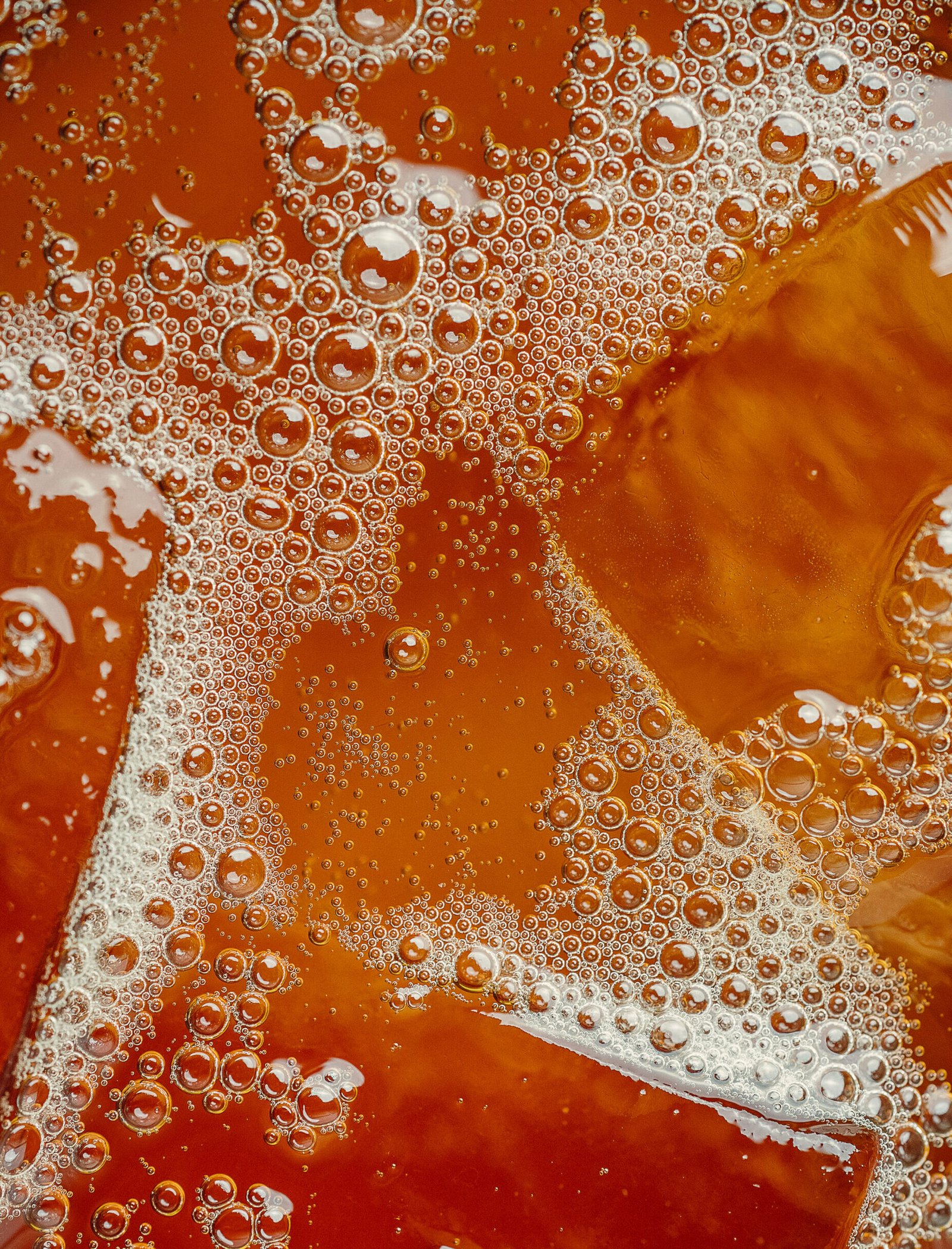 Macro of amber bubbles in an iced drink